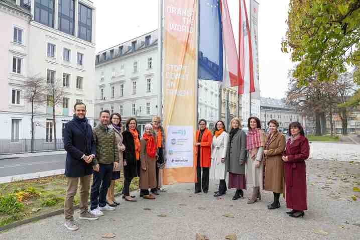 Politikerinnen und Politiker vor der orangenen Fahne
