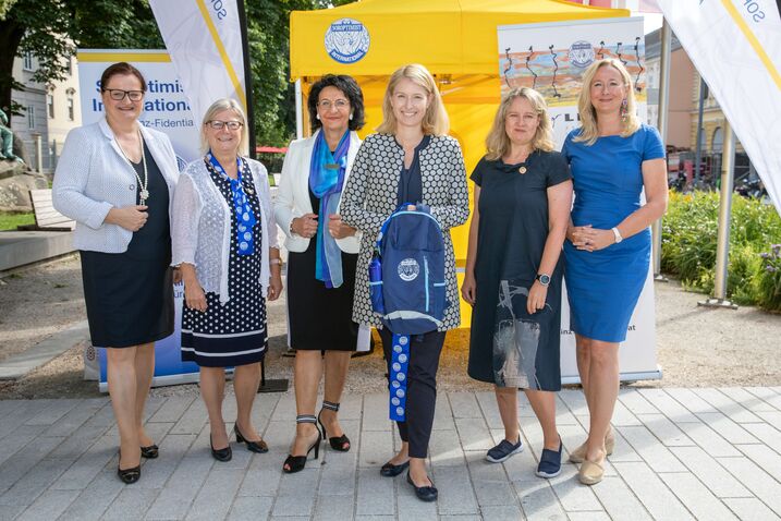 5 Präsidentinnen der Soroptimistinnen mit Landeshauptmann-Stellvertreterin Mag.a Christine Haberlander, die einen blauen Rucksack in die Kamera hält
