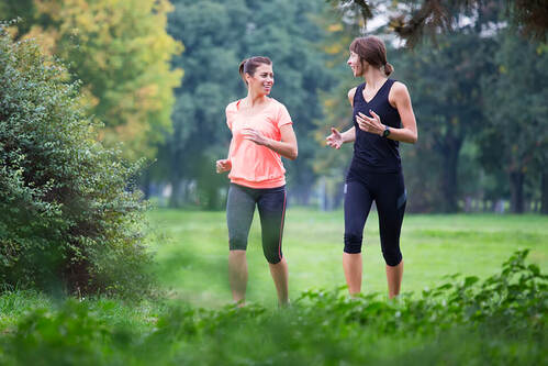 Zwei junge Frauen betätigen sich sportlich beim Laufen.