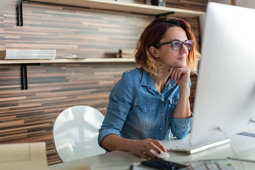 Junge Frau arbeitet in einem Design Studio am Computer.